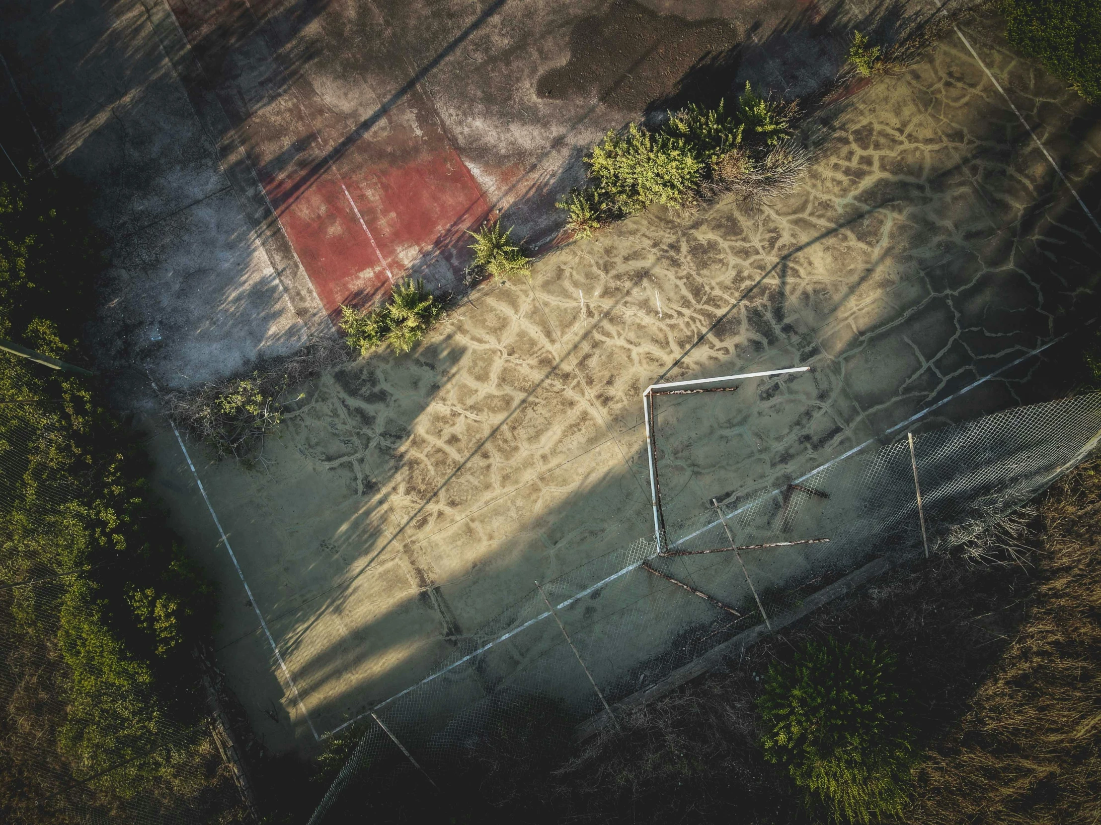 an aerial view of an abandoned basketball court, inspired by Elsa Bleda, unsplash contest winner, realism, late afternoon, 15081959 21121991 01012000 4k, jungle grunge, harsh sunlight