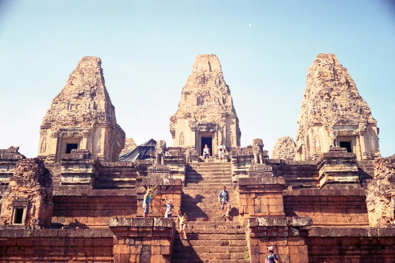 a group of people climbing up the side of a building, an album cover, unsplash contest winner, angkor thon, tall stone spires, analogue, steps