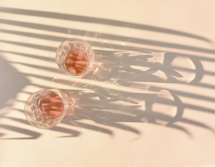 a couple of wine glasses sitting on top of a table, by Emily Shanks, pexels contest winner, photorealism, pink shadows, consist of shadow, clear lines, abstract photography