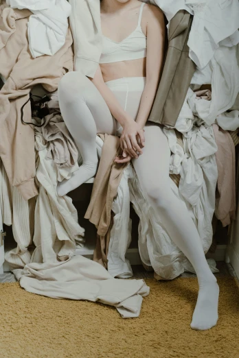 a woman sitting on top of a pile of clothes, inspired by Vanessa Beecroft, pexels contest winner, renaissance, wearing white tights, beige colors, plastic and fabric, ivory rococo
