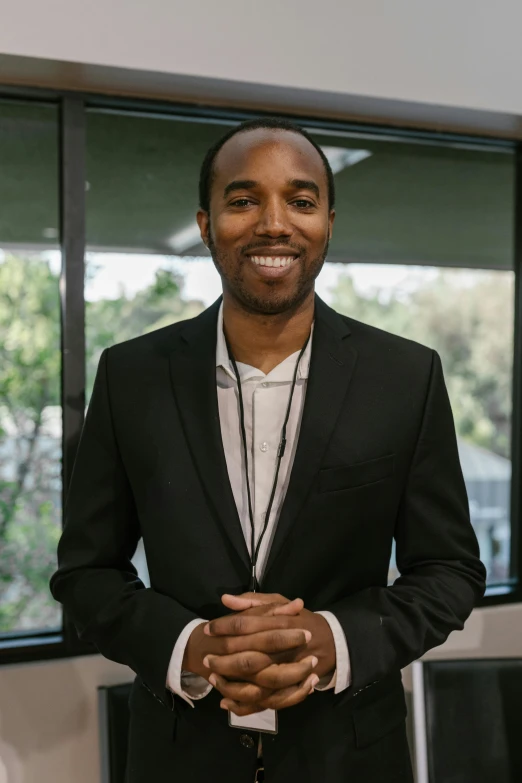 a man in a suit standing in front of a window, by Jesse Richards, donald glover, professional profile picture, in an office, avatar image