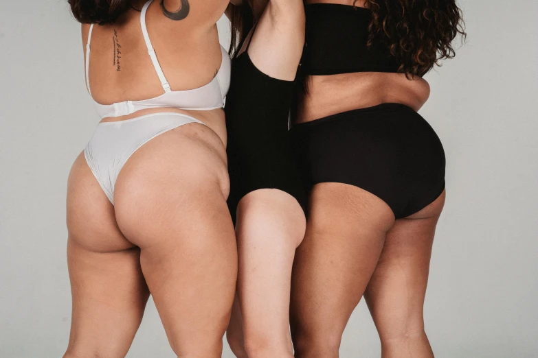 a group of three women standing next to each other, by Matija Jama, trending on pexels, renaissance, cute panties, thick body, white and black, plain background