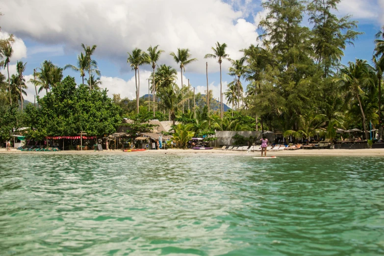 a group of people standing on top of a sandy beach, lush green, thai, viewed from the ocean, seraphine