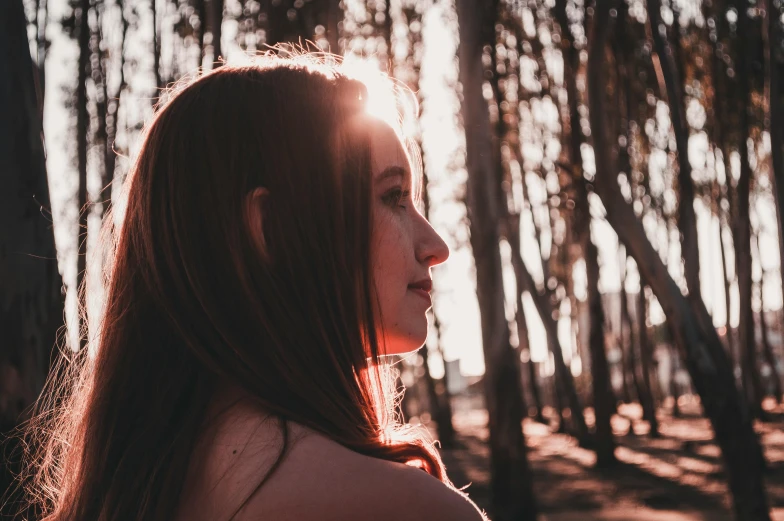 a woman standing in the middle of a forest, pexels contest winner, aestheticism, backlit beautiful face, profile image, girl with brown hair, pink sunlight