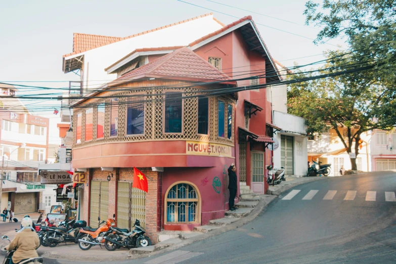 a group of motorcycles parked on the side of a road, pexels contest winner, art nouveau, vietnamese temple scene, red building, 90's photo, built on a steep hill