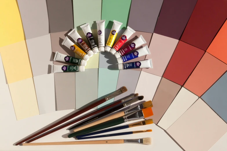 a bunch of paint brushes sitting on top of a table, a photorealistic painting, inspired by Kyffin Williams, unsplash, hilma af klint color palette, full colour spectrum, jpeg artefacts on canvas, red and purple palette