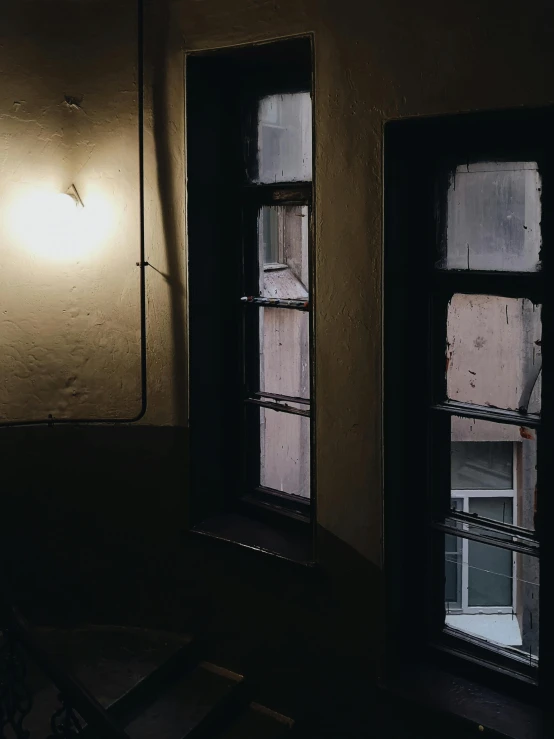 a couple of windows sitting next to each other, inspired by Elsa Bleda, creepy backrooms, low quality photo, brown atmospheric lighting, historical photo