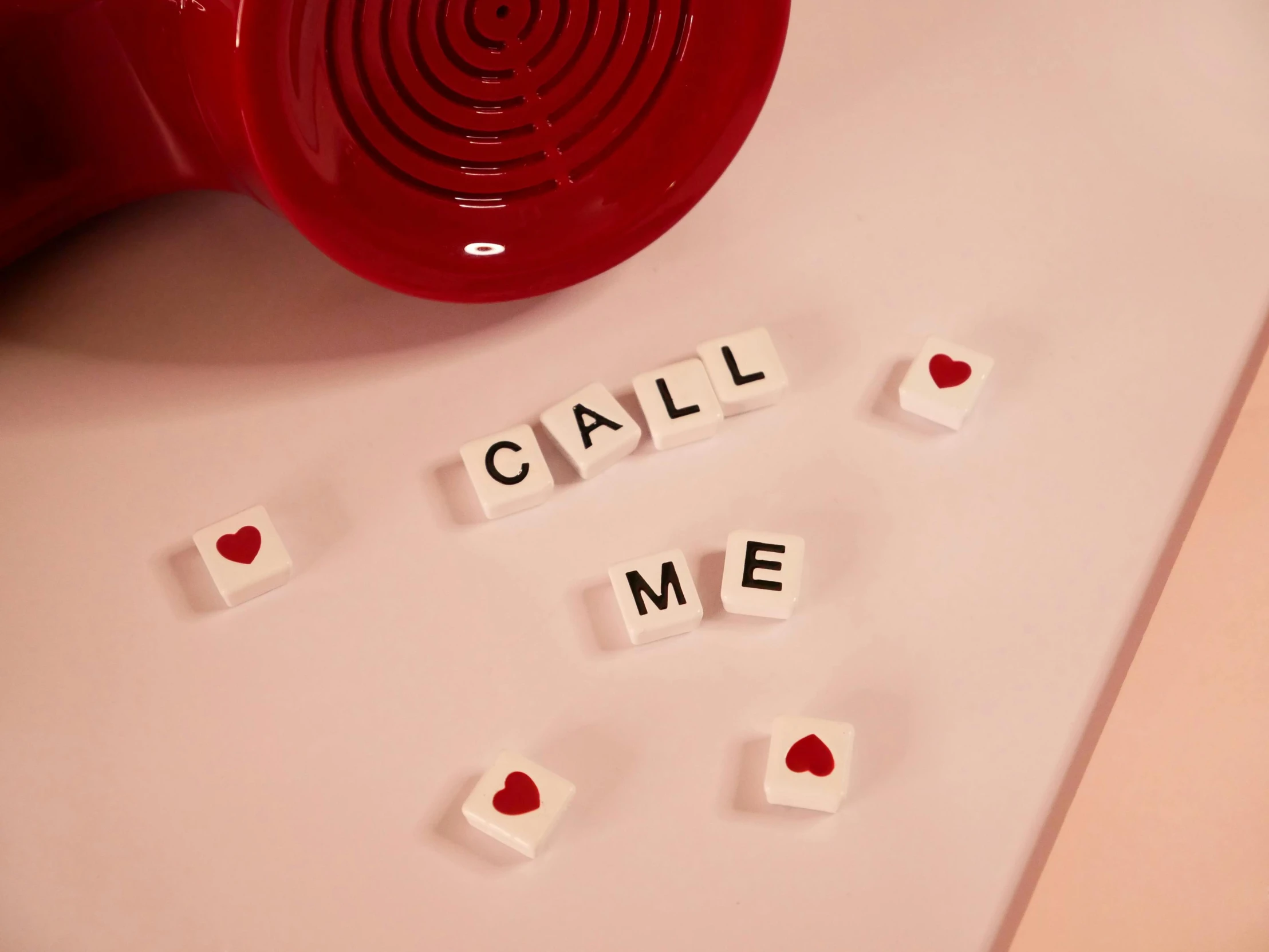 a red telephone sitting on top of a white counter, inspired by Carrie Mae Weems, letterism, red hearts, cubes, help me, detail shot