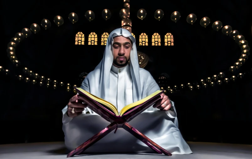a man in a white robe is reading a book, a portrait, inspired by Sheikh Hamdullah, pexels contest winner, he is casting a lighting spell, sitting down, promotional image, professional picture