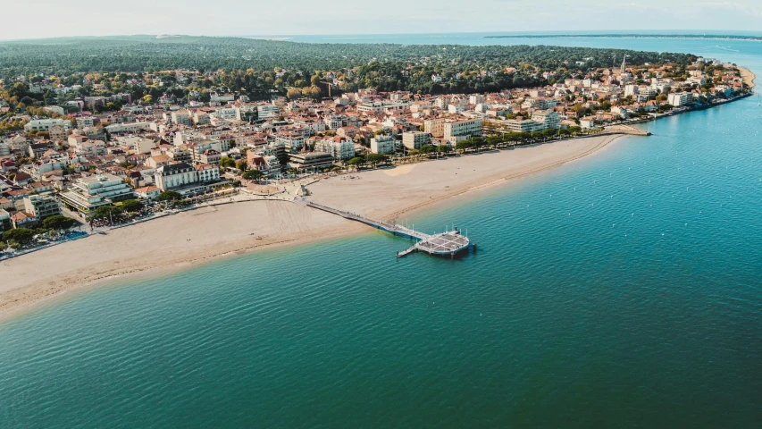 a large body of water next to a beach, by Raphaël Collin, pexels contest winner, surrounding the city, aerial footage, profile image