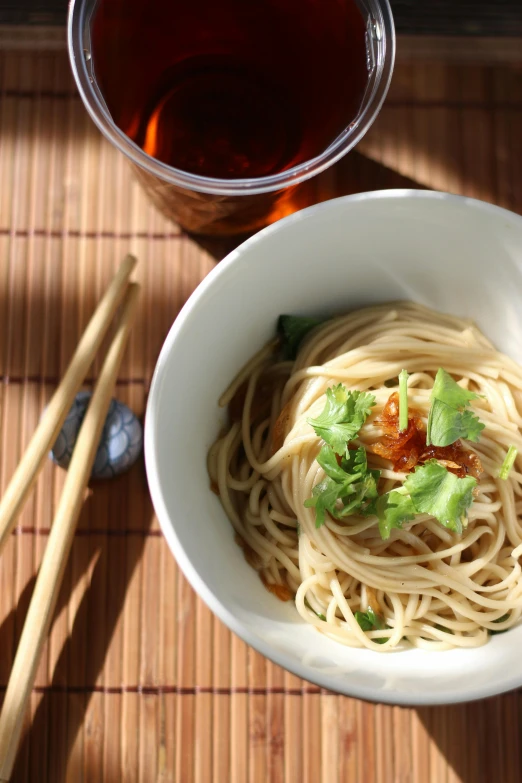 a bowl of noodles and chopsticks next to a cup of tea, a portrait, flickr, promo image, epicurious, spaghetti, square
