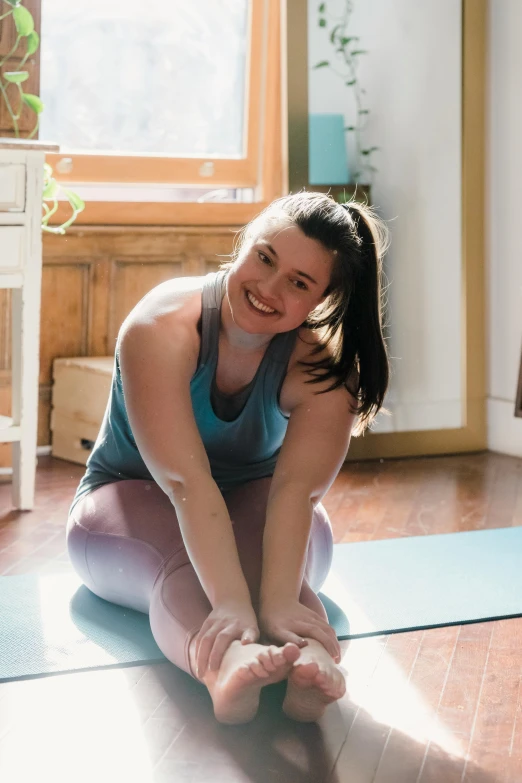 a woman sitting on a yoga mat in front of a window, by Arabella Rankin, smiling slightly, pixeled stretching, promo image, kyle mclaughlin