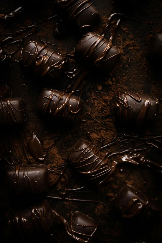 a pile of chocolate covered strawberries sitting on top of a table, a still life, trending on pexels, black textured, banner, meteorites, dark chocolate painting