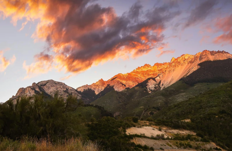 a fire hydrant in the middle of a field with mountains in the background, a picture, unsplash contest winner, baroque, red and orange glow, manuka, rocky mountains and a river, panoramic