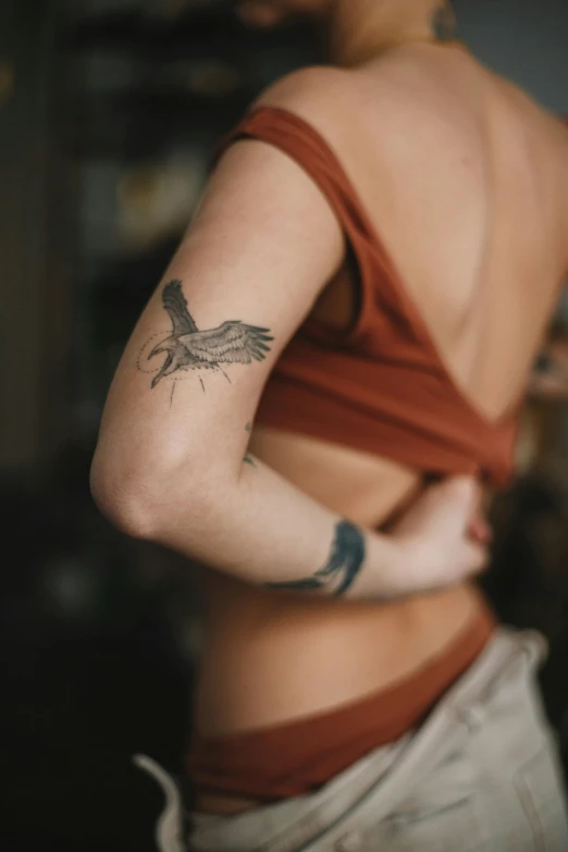a woman with a tattoo on her back, a tattoo, by Adam Marczyński, pexels contest winner, an eagle, skinny upper arms, arms open, synthetic bio skin