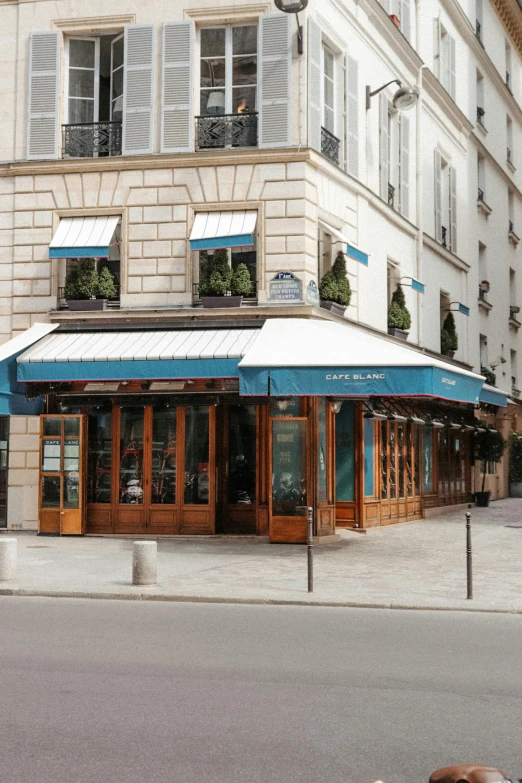 a red fire hydrant sitting on the side of a road, paris school, blue shutters on windows, restaurant, blue robes, white marble buildings