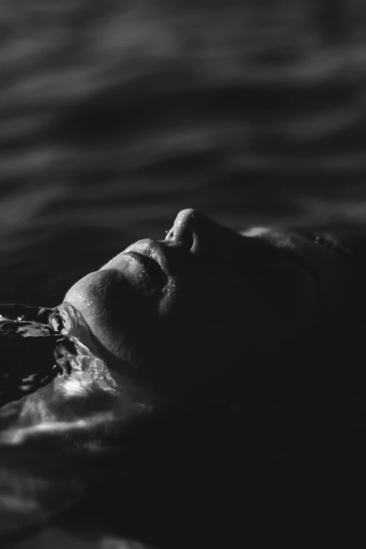 a woman floating in a body of water, a black and white photo, unsplash, solemn face, summer night, miro petrov, sunlight