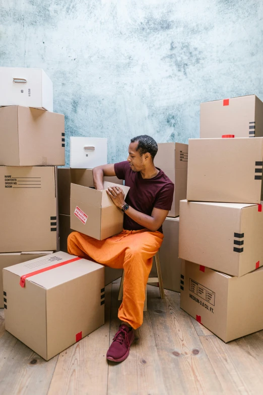 a man sitting on top of a pile of boxes