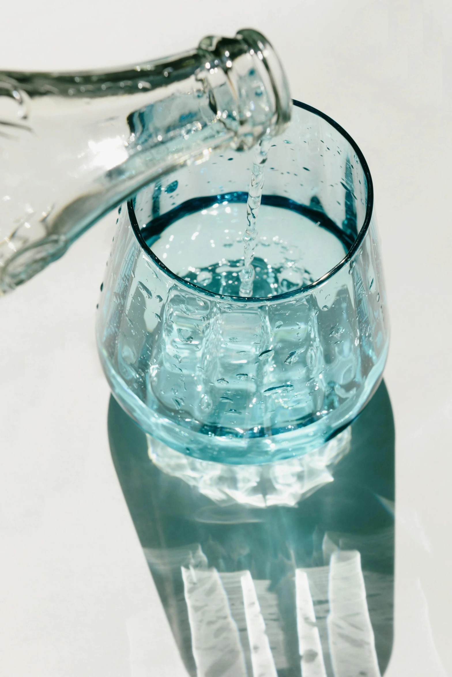 a bottle of water is being poured into a glass, by Carey Morris, aquamarine, detailed product image, small glasses, clear