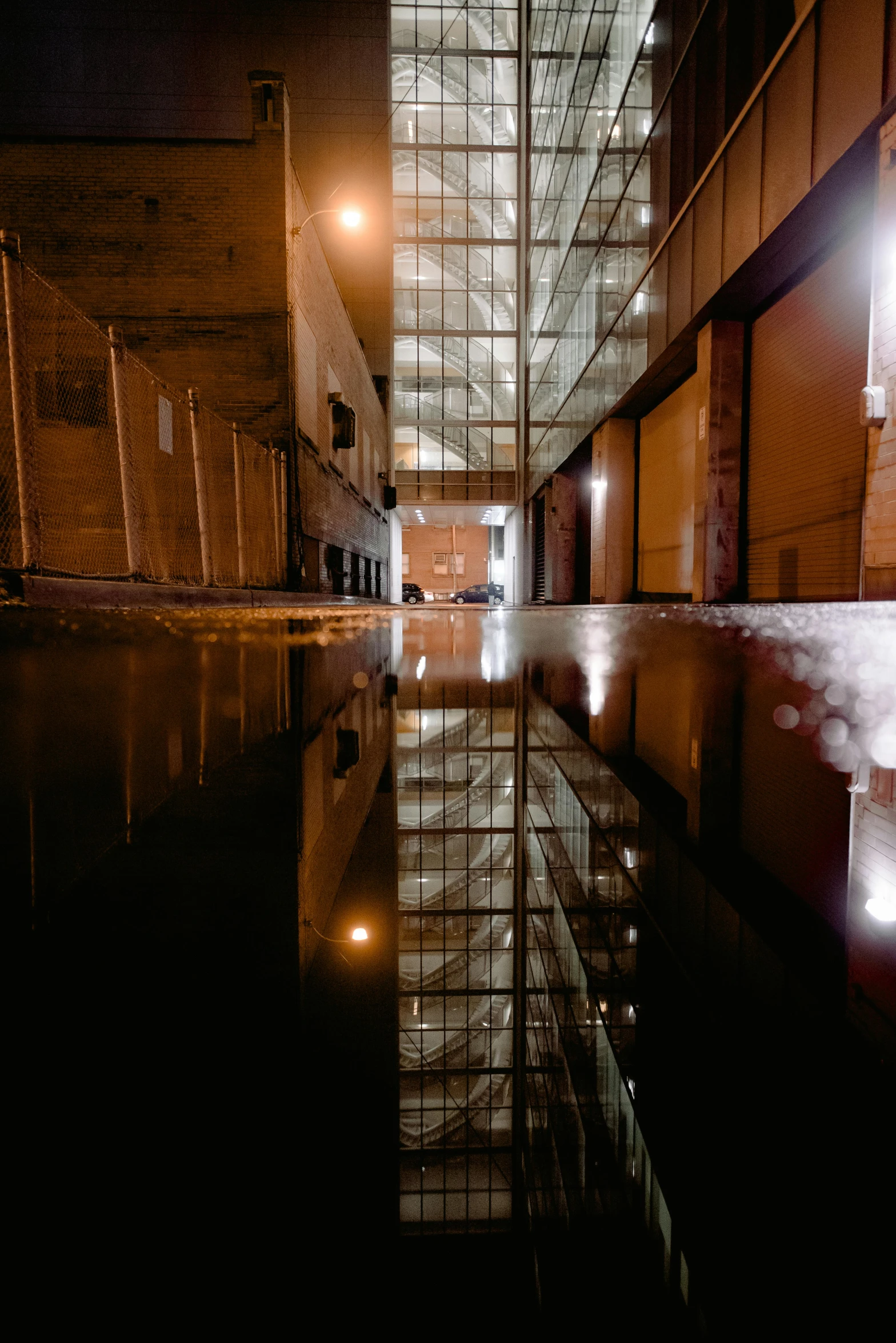 a reflection of a building in a puddle of water, a portrait, unsplash, abandoned night hangar, location [ chicago ( alley ) ], wideangle, day after raining