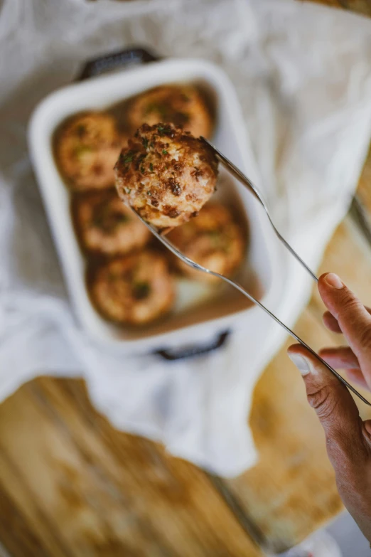 a person holding a fork with some food on it, unsplash, arabesque, crispy buns, bulbous, bottom angle, teaser