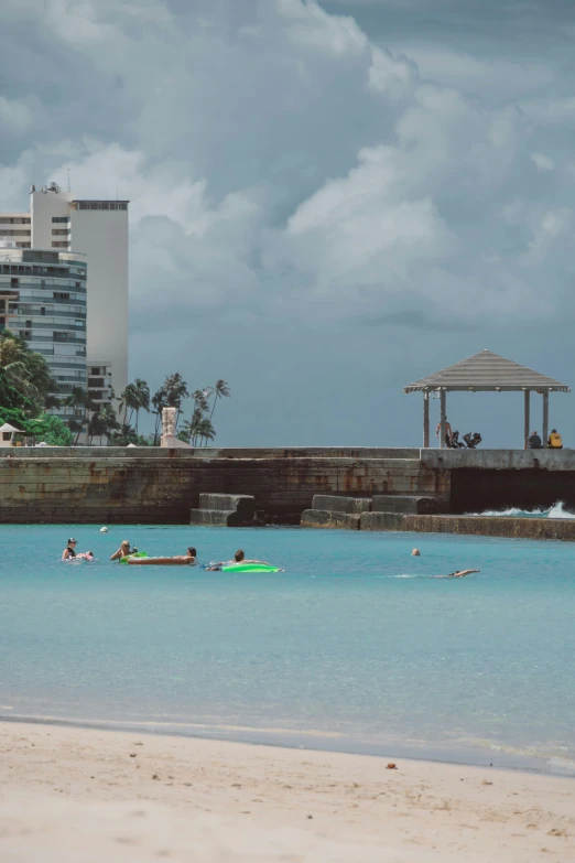 a man riding a surfboard on top of a sandy beach, swimming pool, floating buildings, puerto rico, people drowning