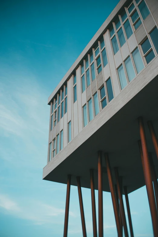 a tall building sitting on top of a sandy beach, inspired by Tadao Ando, unsplash, brutalism, reykjavik junior college, seen from below, college, 1 4 9 3