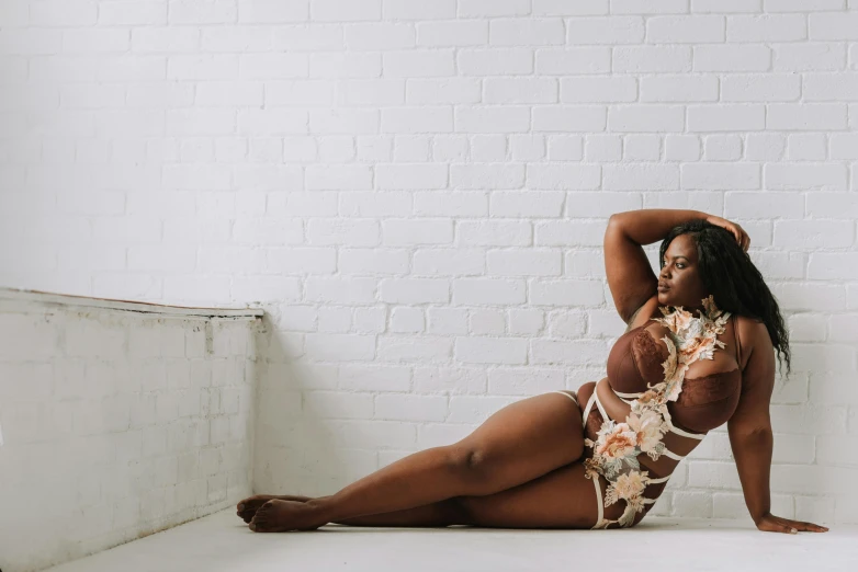 a woman in a bikini sitting on the floor, inspired by Esaias Boursse, unsplash, arabesque, plus size, brown skin, honey birdette, in front of white back drop