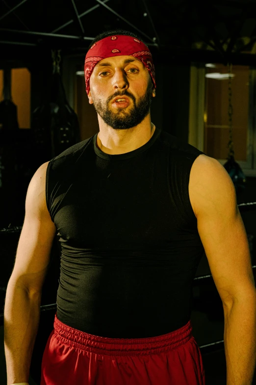 a man in a black shirt and red shorts, an album cover, inspired by Volkan Baga, rugged man portrait, in a gym, headshot photo, balaclava