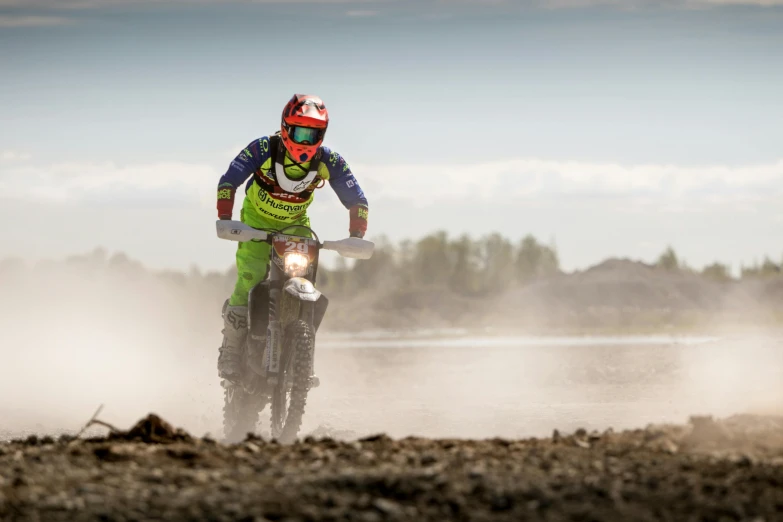 a person riding a dirt bike on a dirt road, by Dietmar Damerau, unsplash, massive vertical grand prix race, nina tryggvadottir, tjalf sparnaay 8 k, profile image