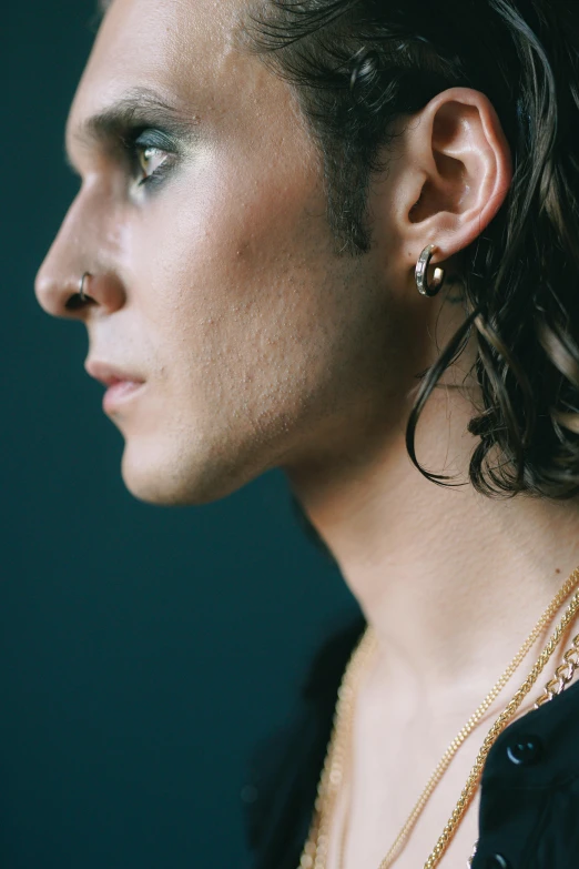 a close up of a person wearing a necklace, an album cover, trending on pexels, hyperrealism, mullet haircut, timothee chalamet, small studded earings, prideful look