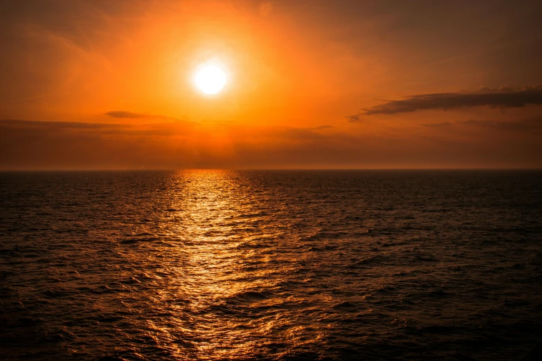 the sun is setting over the ocean, pexels contest winner, romanticism, middle of the ocean, halogen, orange glow, long