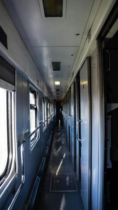 a view of the inside of a train car, by Attila Meszlenyi, rows of doors, an approaching shadow, 8k octan photo