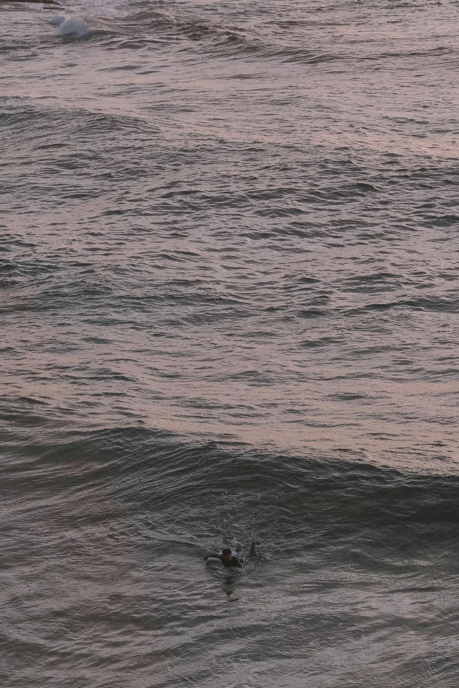 a man riding a wave on top of a surfboard, inspired by Andreas Gursky, happening, overcast dusk, very poor quality of photography, some pink, tar pit