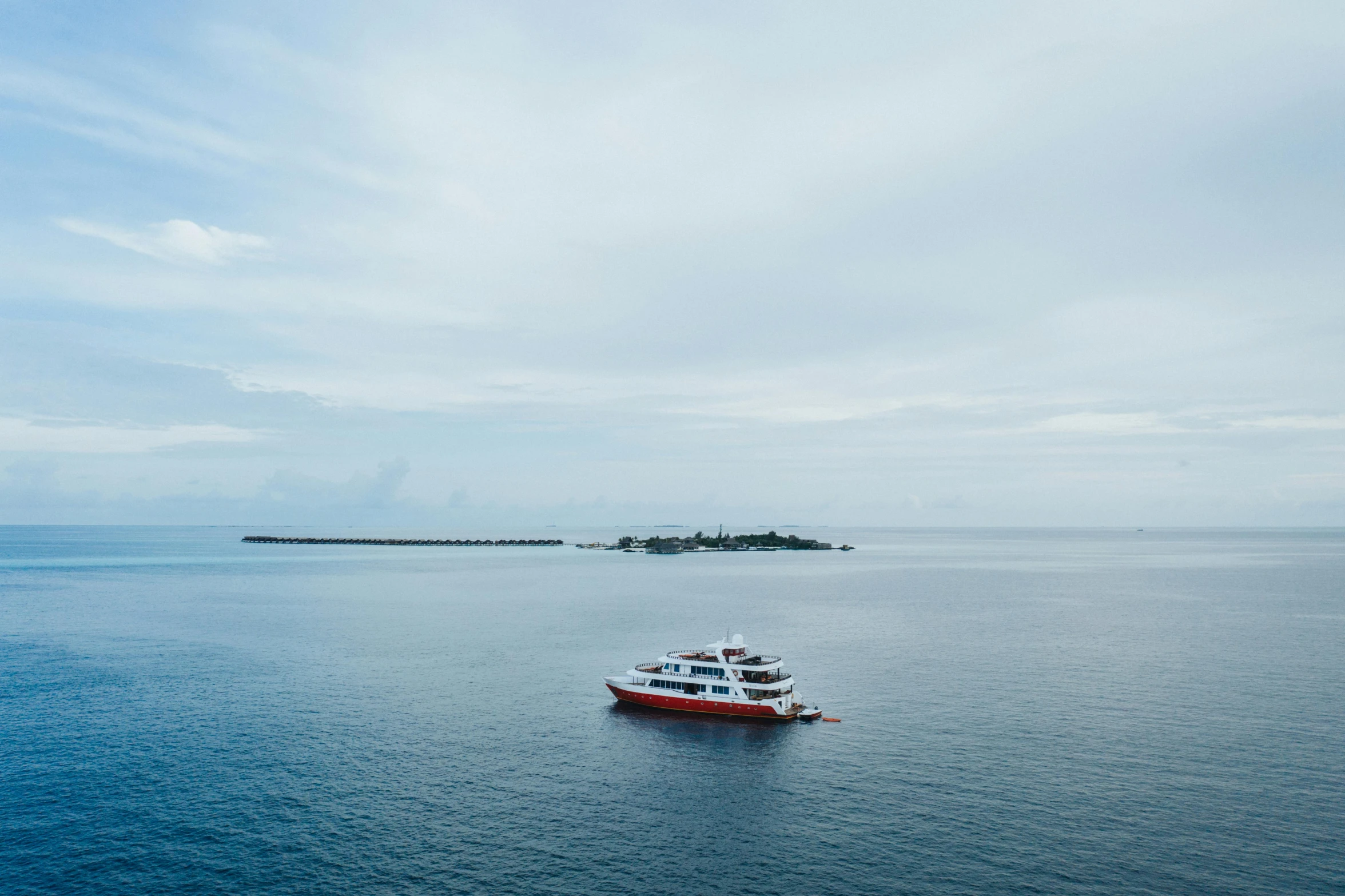 a boat in the middle of a large body of water, pexels contest winner, hurufiyya, maldives in background, an island made of red caviar, wide high angle view, hd footage