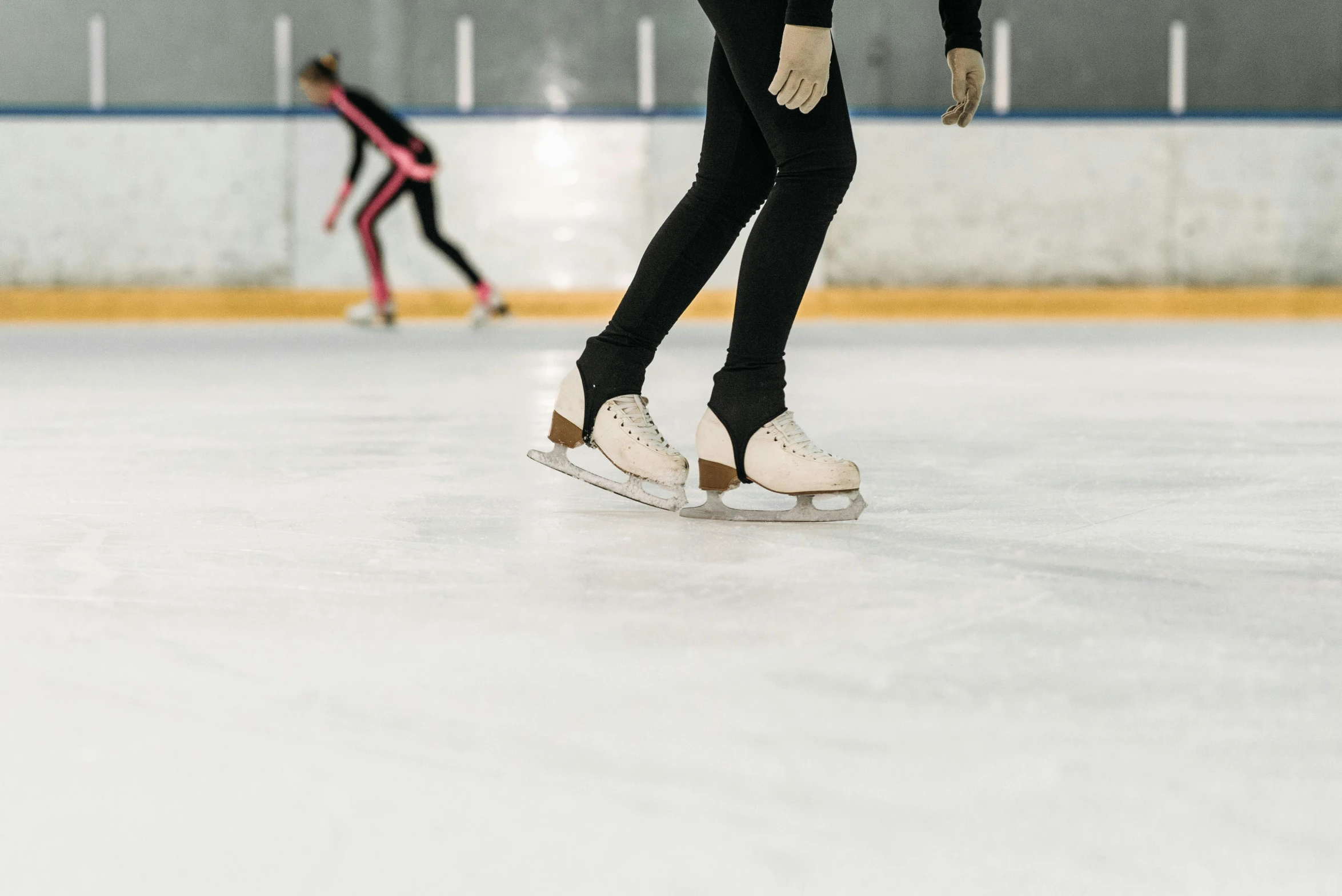 a couple of people skating on top of an ice rink, trending on pexels, arabesque, middle close up shot, standing sideways, single figure, indoor