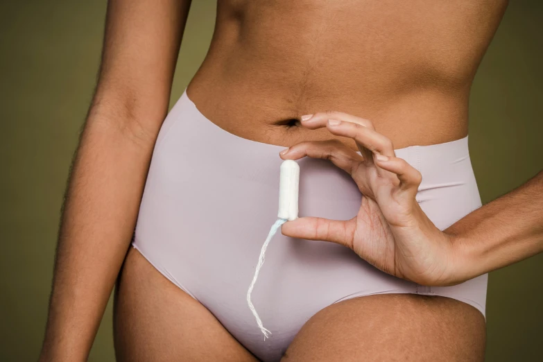 a close up of a person in a panties holding a device, plasticien, detailed product image, porcelain organic tissue, hegre, manuka