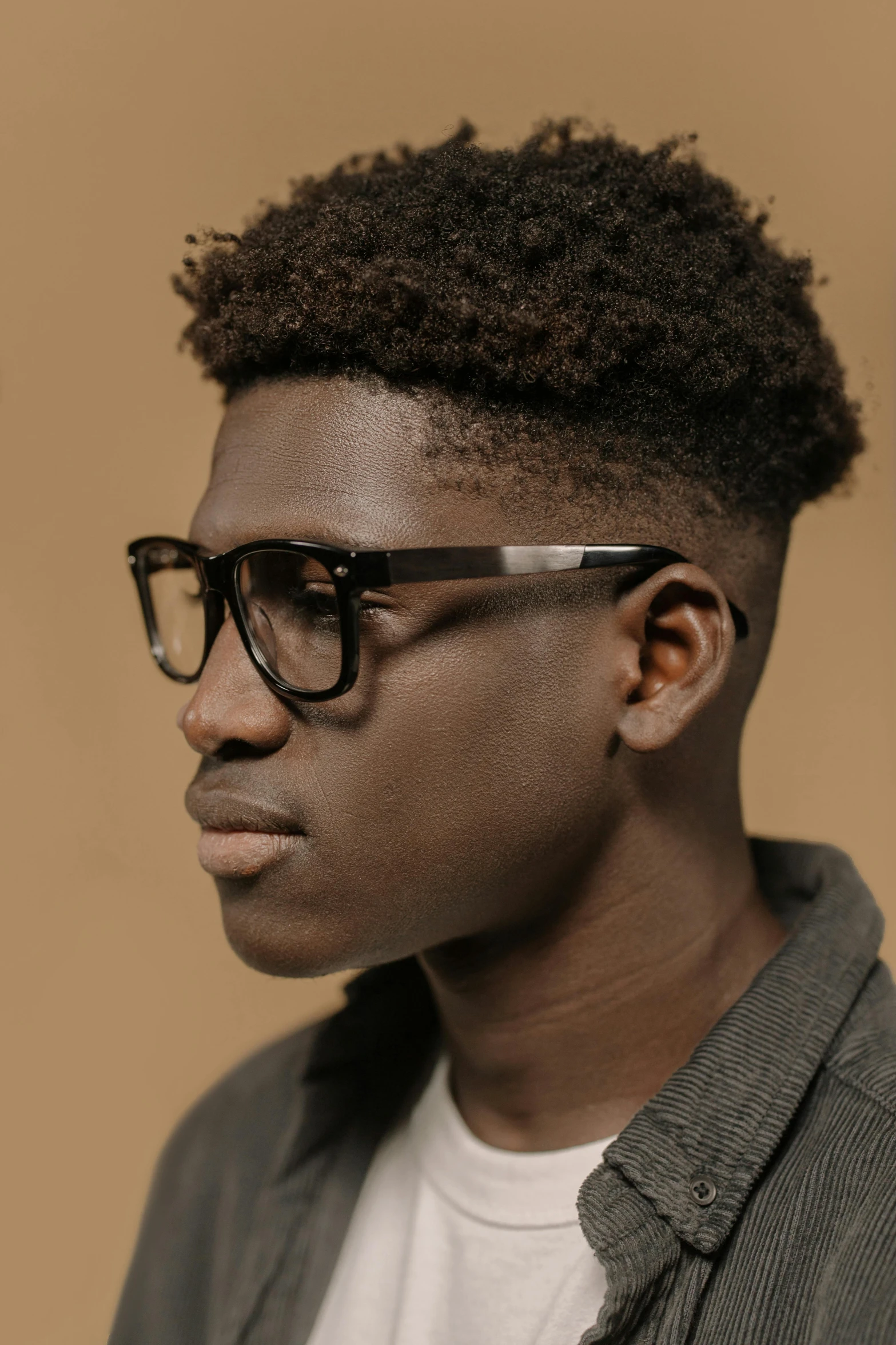 a close up of a person wearing glasses, inspired by Theo Constanté, ebony, black main color, young man, teenage boy
