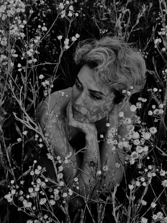 a black and white photo of a woman in a field of flowers, by Lucia Peka, conceptual art, sean young, sophia lillis, camouflage made of love, vania zouravliov