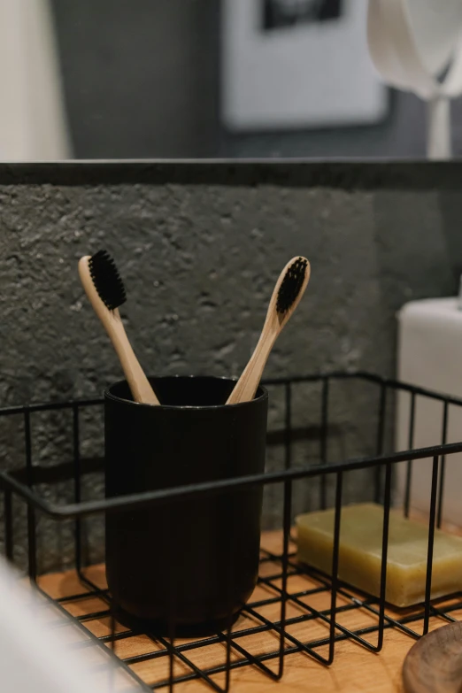 a close up of a toothbrush holder on a counter, unsplash, black vertical slatted timber, profile image, shelf, sustainability