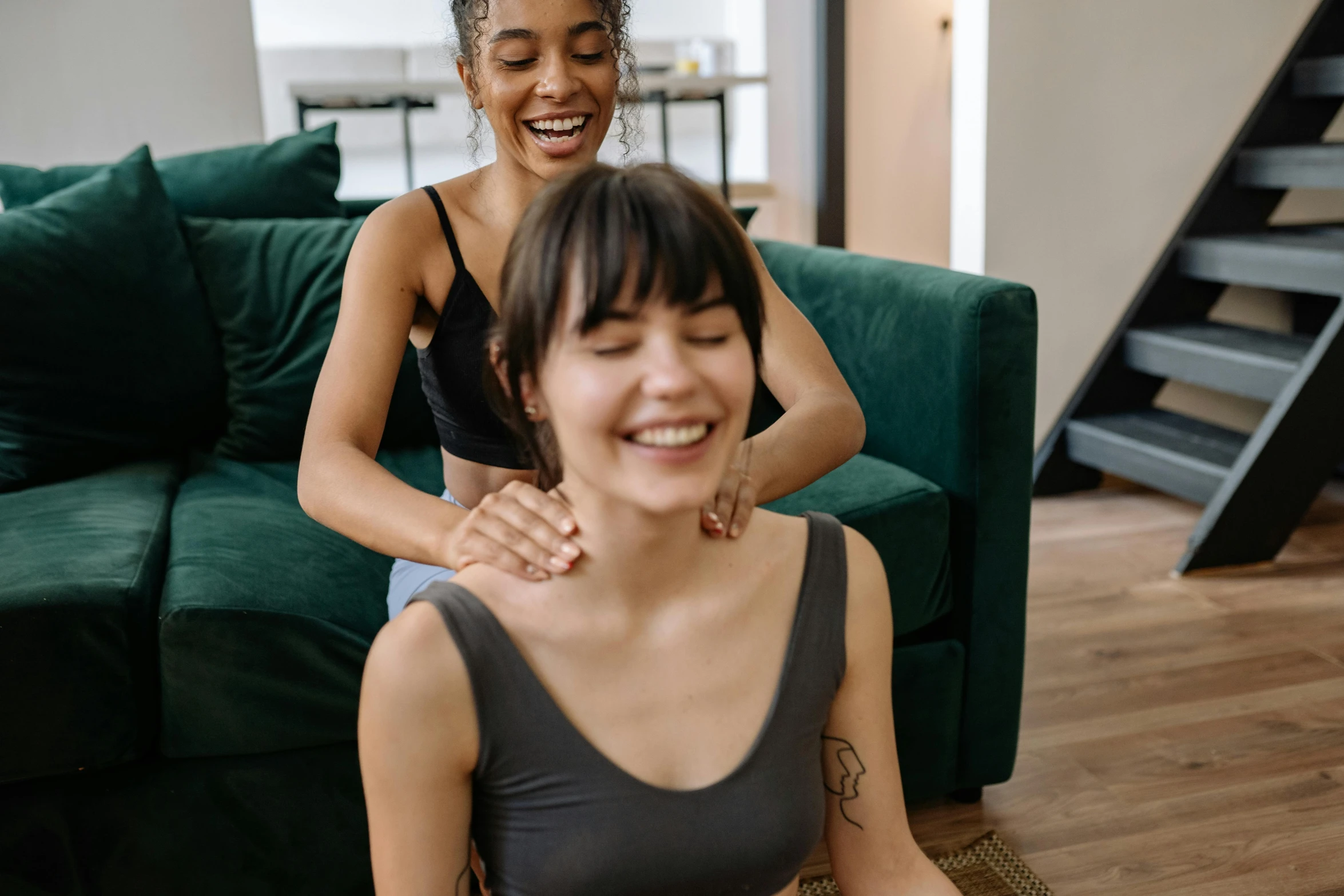 a woman sitting on top of a green couch next to a woman, by Emma Andijewska, trending on pexels, earing a shirt laughing, acupuncture treatment, thick neck, straya