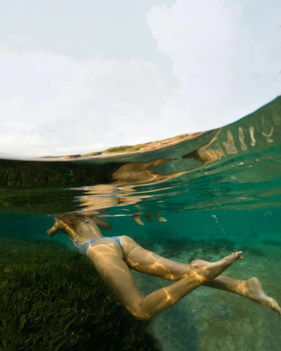 a woman in a bikini swims in the water, a picture, by Jessie Algie, fish lens, national geography photography, rainbow tubing, ignant