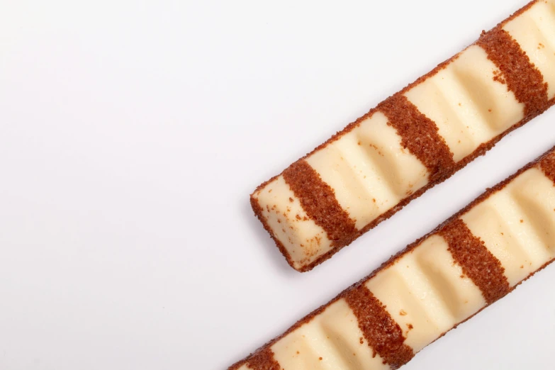 two pieces of cake sitting on top of a white table, inspired by Joris van der Haagen, unsplash, square lines, vanilla, medium close-up shot, rung