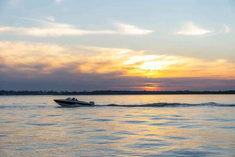 a boat traveling across a body of water at sunset, mastercraft, fan favorite, thumbnail, high resolution photo