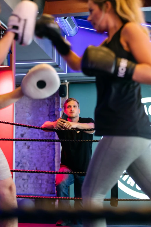 a couple of women standing next to each other in a boxing ring, happening, in a planet fitness, vivid light, spiralling, manuka
