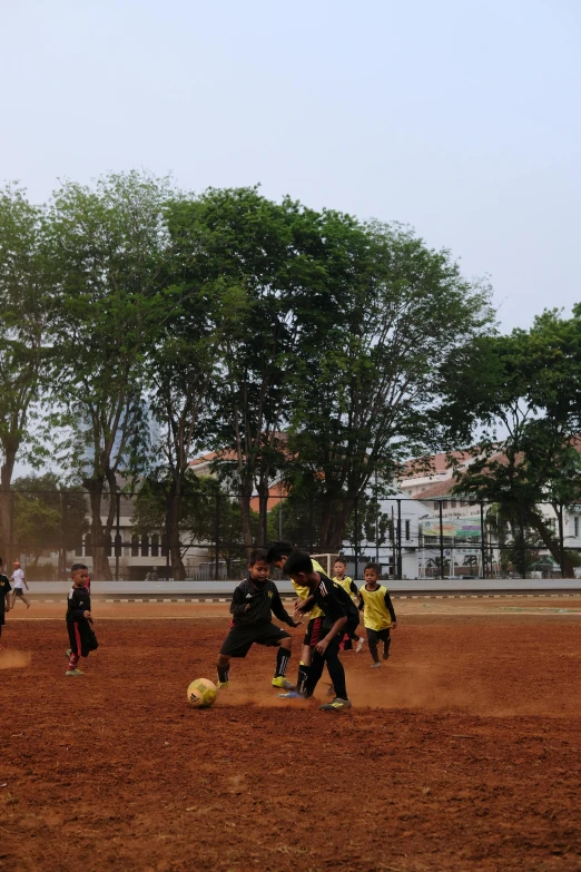 a group of young men playing a game of soccer, by Basuki Abdullah, dribble, low quality photo, panoramic view of girl, square, clay