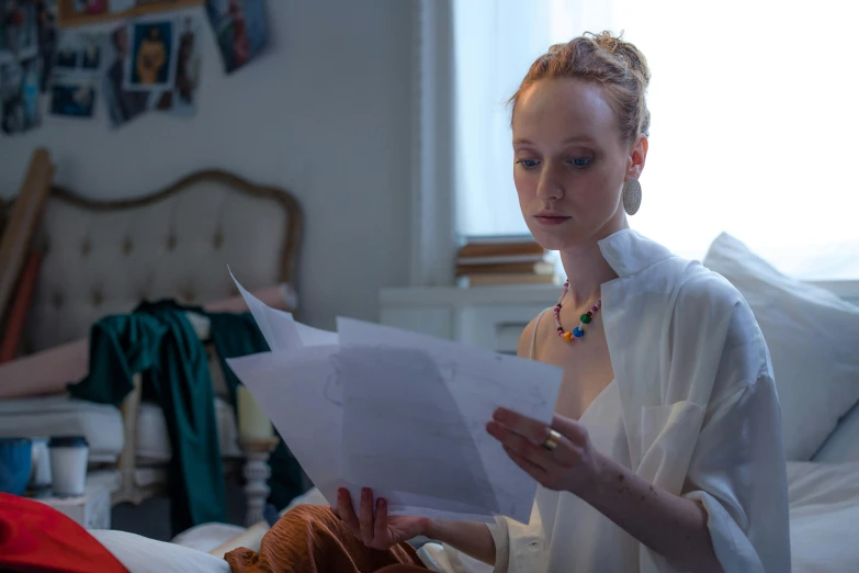 a woman sitting on a bed reading a piece of paper, pexels contest winner, hyperrealism, hr ginger, evanna lynch, eleanor tomlinson, large and in charge