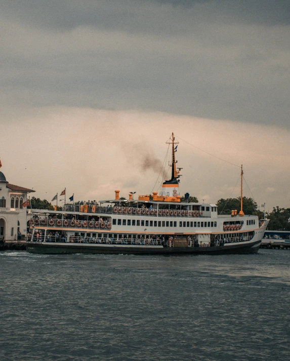 a large boat floating on top of a body of water, a colorized photo, pexels contest winner, hurufiyya, istanbul, non-binary, white steam on the side, 🚿🗝📝