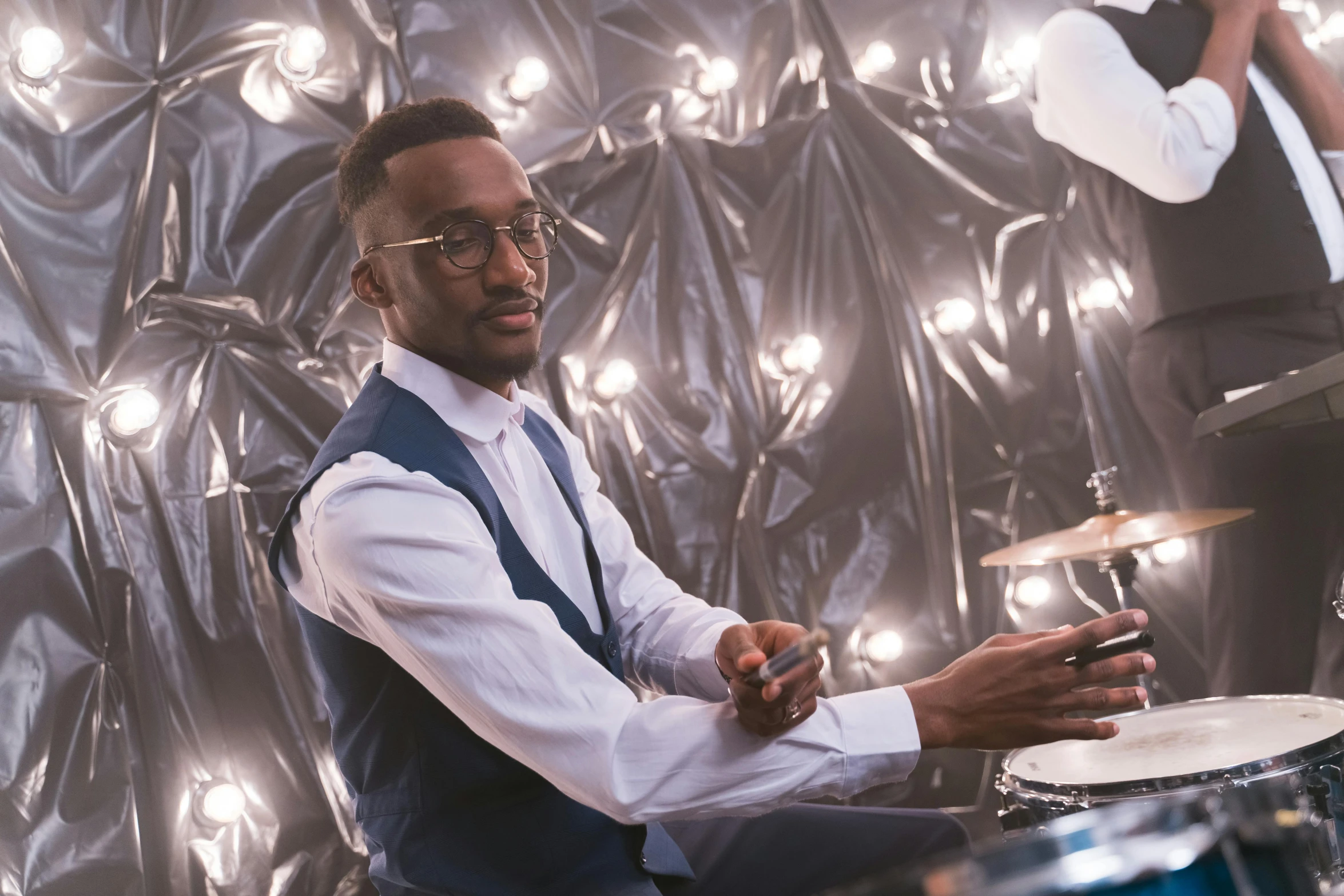 a man sitting in front of a drum kit, inspired by Michael Ray Charles, pexels contest winner, photorealism, african aaron paul, attractive male playing piano, flashing lights, nerdy music teacher with phd