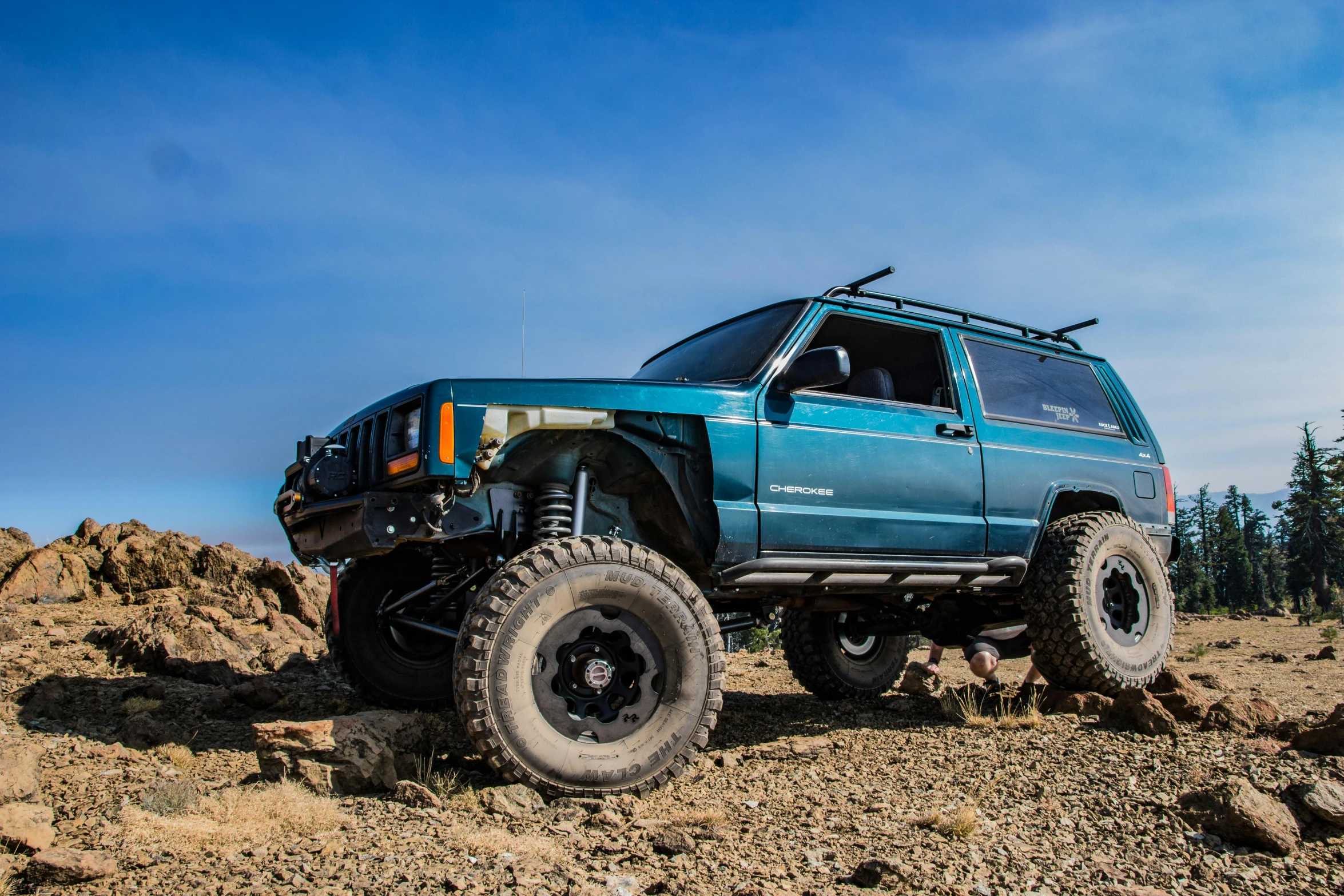 a blue jeep parked on top of a rocky hill, a portrait, unsplash, 90's photo, pulling the move'derp banshee ', ultra 4k, full body shot